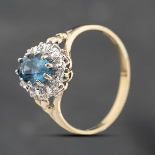 Pre-Owned 9ct Yellow Gold Blue Topaz & 0.05ct Diamond Heart Engraved Shoulders Oval Cluster Ring 43451021